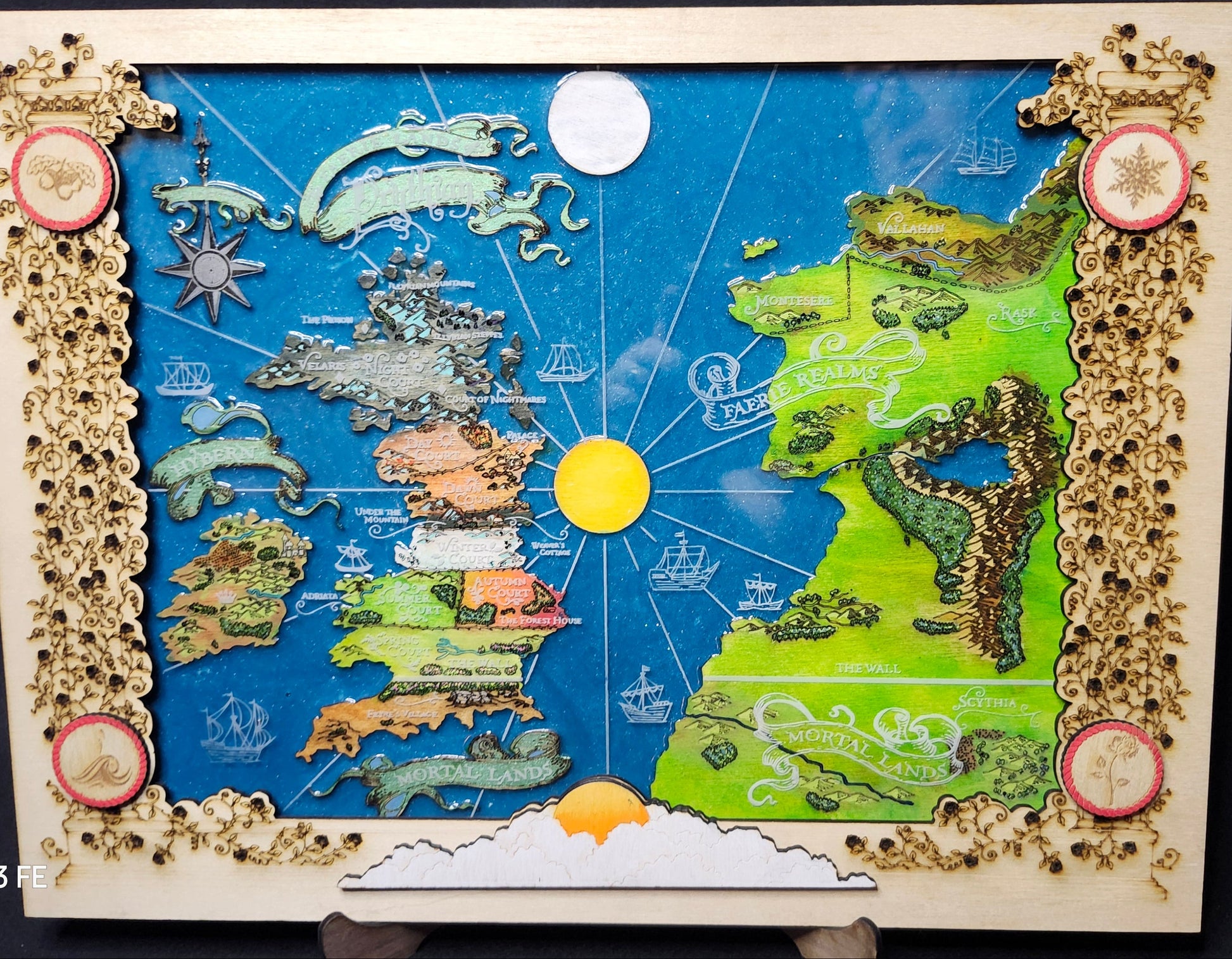Handcrafted wooden map of Prythian with detailed illustrations of various faerie courts including Spring, Night, Winter, Autumn, Dawn, Day, and Summer.