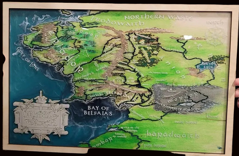 A framed fantasy map artwork showing regions like the Shire, Lonely Mountain, and Bay of Belfalas and more
