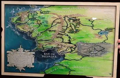 A framed fantasy map artwork showing regions like the Shire, Lonely Mountain, and Bay of Belfalas and more