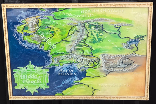A Middle Earth map featuring a stylized fantasy illustration of the fictional continent, complete with a decorative border 